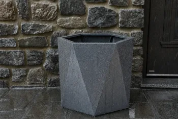 Cvetlično korito HX 50x50 cm RAL 9007 FS na zunanji terasi ob kamniti steni v dežju