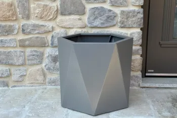 Cvetlično korito HX 50x50 cm RAL 9007 FS pred kamnito steno na zunanji terasi